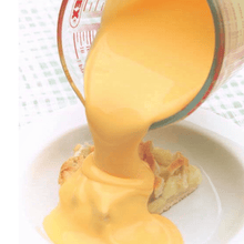 cheese pouring from a Borosilicate PYREX measuring cup